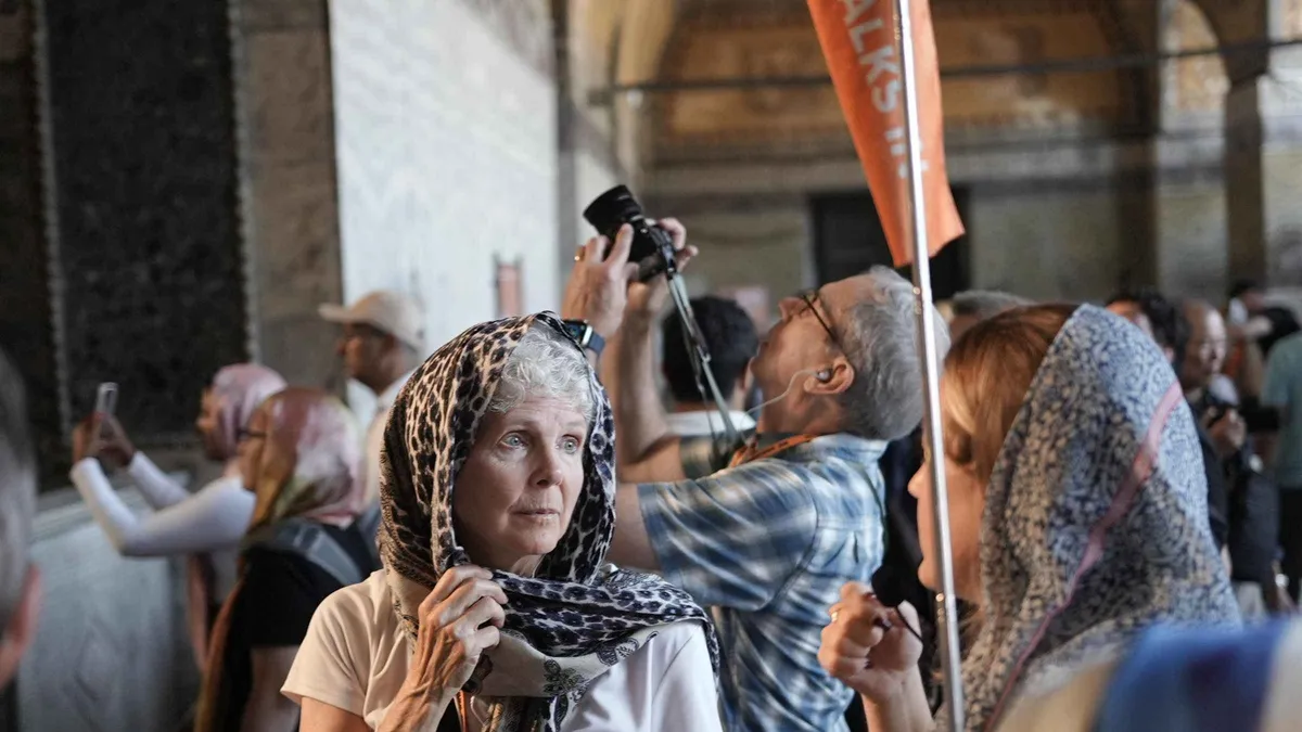 Guide with a small group in front of the six minarets of the Blue Mosque in Istanbul, Türkiye